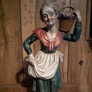 Figurine, Lady carrying basket on shoulder and holding up her apron